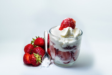 Closeup of fresh strawberries, sugar and dessert isolated on white background.