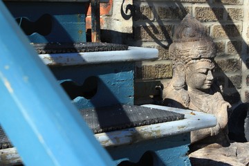 Buddha statue in private property urban garden by blue stairs on sunny day in Montreal, May 2020, keep calm and everything will be fine concept hope symbol during Covid-19 coronavirus outbreak