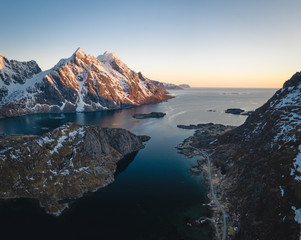 Aerial picture of a fjord in north of norway. Located in the Lofoten islands. Snowy mountains during sunset. Soft sunset light and beautiful landscape. 