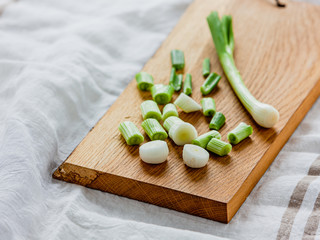 geschnittene Frühlingszwiebeln auf einem Eichebrett