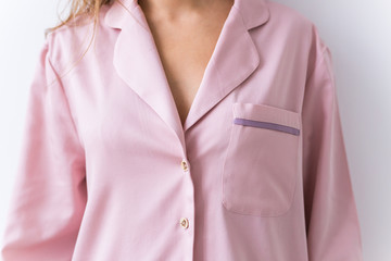 Close-up of woman dressed in beautiful pink pajama posing in her living room. Comfortable sleepwear, home relaxation and female fashion concept.