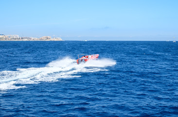 Fototapeta premium Red speed boat on blue water