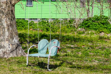 Home made tree swing made from metal chair in ninth ward neighborhood of New Orleans, Louisiana, USA