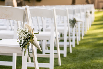wedding ceremony aisle with chairs and flowers
