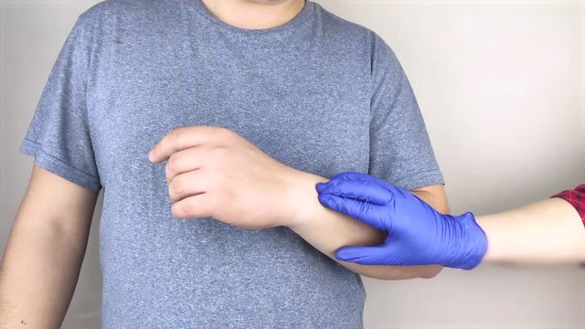 A man suffers from elbow pain. Damaged elbow joint, bone fracture, or sprain. Hand injury and flexion pain concept