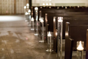 indoor wedding ceremony aisle with benches and candles