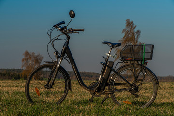 Black electric bike on ski slope in Budweis city with windy trees