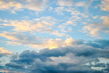 Fototapeta premium White fluffy clouds in blue sky at sunset