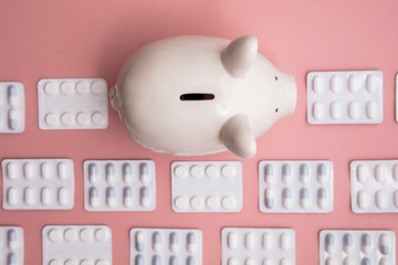 Healthcare cost. Money box piggy bank with packets of pills and tablet
