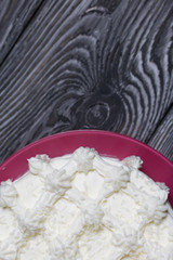 Cake decorated with cream cream. On top of the decoration in the form of snowflakes. Located on brushed pine boards painted black.