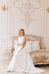 Fototapeta premium Portrait of the bride. Young girl, blonde with a short haircut. Full growth plan, vintage. Posing beautifully.