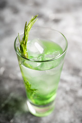 Sweet tequila based green cocktail with tarragon and rosemary. Selective focus. Shallow depth of...