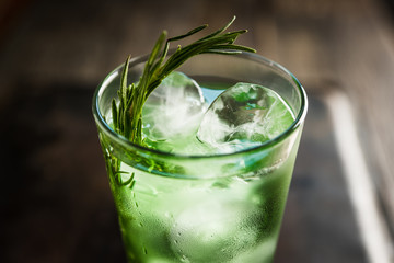 Sweet tequila based green cocktail with tarragon and rosemary. Selective focus. Shallow depth of field.