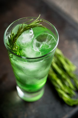 Sweet tequila based green cocktail with tarragon and rosemary. Selective focus. Shallow depth of field.