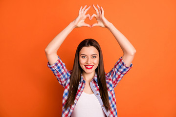 Obraz na płótnie Canvas Portrait of positive cute lovely sweet girl show heart shape finger symbol enjoy boyfriend love date wear checkered clothes isolated over shine color background