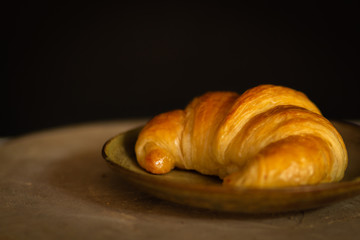  fresh baked croissant on dish close up 