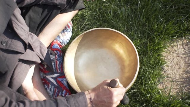 A qigong master conducts meditation using a gong and Crystal bowl, Crystal Tibetian singing bowl, a master meditates receives energy for the body