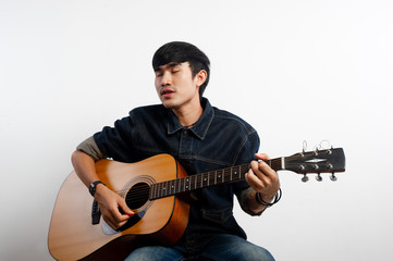 Obraz premium The acoustic guitarist is holding the guitar. And playing guitar Concepts of hobbies and relaxation in free time for good quality of life