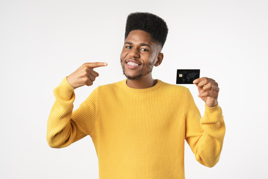 Afro american customer man holding credit card pointing with finger standing over isolated white background