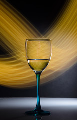 glass of wine on black background with yellow neon lights