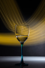 wine glass on black background with yellow neon trails