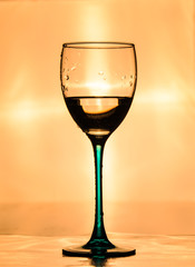 Transparent wine glass on orange background