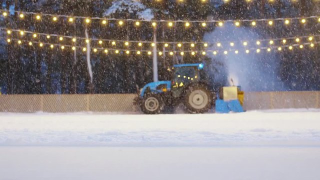 machines, season and winter concept - tractor with ice resurfacer or snow blower on outdoor skating rink