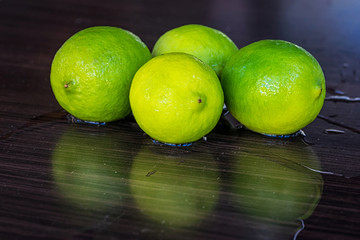 Four fresh limes on a wooden surface