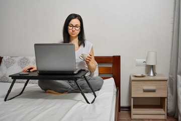 Fototapeta premium woman working on laptop at home in bed