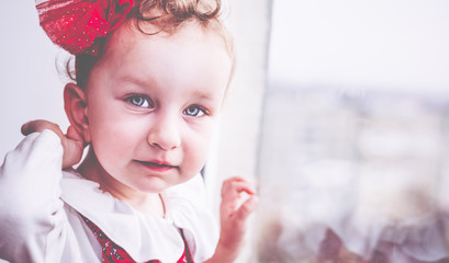 Beautiful playful smiling 2-year-old toddler girl portrait, she looks at the camera. 