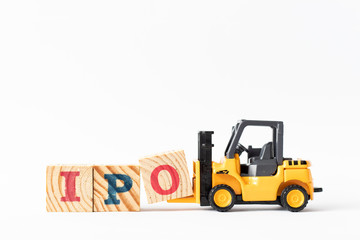 Toy forklift hold wood letter block O to complete word  IPO (Abbreviation of Initial Public Offering) on white background