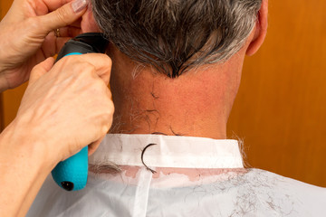 Man having the hair cut on the back of his neck and head with an electric razor