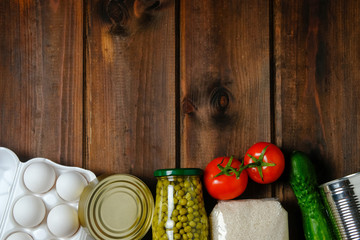 Food donations on a wooden background. Social assistance. Copy space.