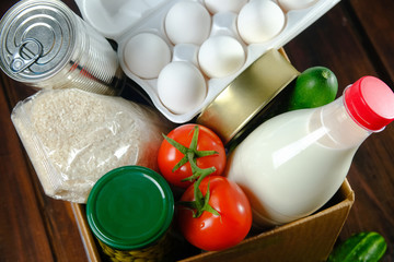 Set of food in a box on a wooden background. Food donations during quarantine and coronavirus.