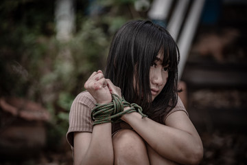 Asian hostage woman Bound with rope at night scene,The thieves kidnapped for ransom,thailand people