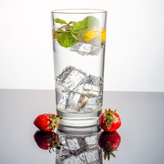 Mineral water with fruit frozen in ice cubes - 345697599