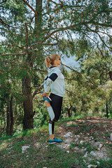 Woman doing yoga poses outside and beautiful view of mountains and forest