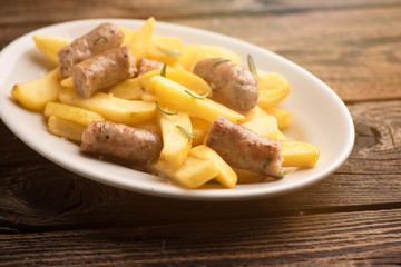 White plate of  italian sausage and potatoes