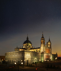 catedral Almudena en madrid al atardecer con el cielo lleno de estrellas y las luces encendidas