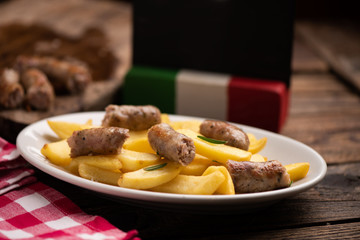 White plate of  italian sausage and potatoes