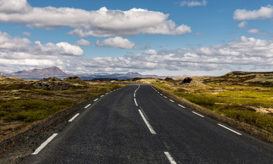 Scenic image of Iceland. Wonderful nature landscape with asphalt road in the mountain valley in sunny day. Amazing tipical Icelandic scenery in summer.  Popular Travel destinations. Touristic concept