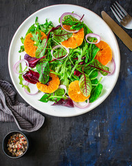 healthy salad tangerines citrus, lettuce, arugula and other herbs. Menu concept food background, keto or paleo diet. top view. copy space for text