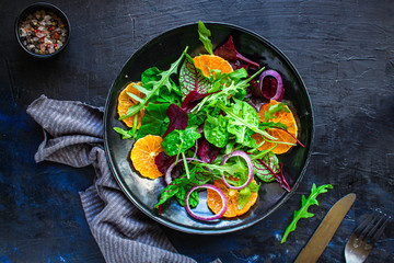 healthy salad tangerines citrus, lettuce, arugula and other herbs. Menu concept food background, keto or paleo diet. top view. copy space for text