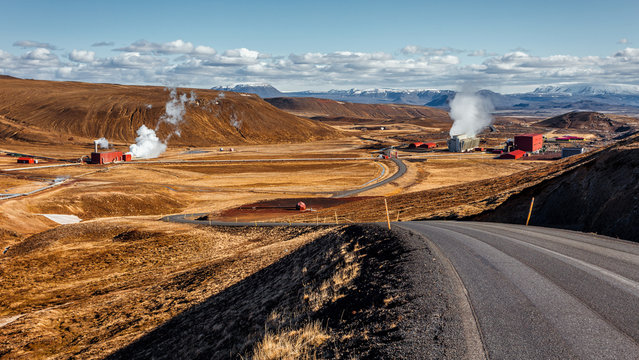 Tipical Icelandic nature landscape. Asphalt road and geothermal power station in th sunny day. Geothermal power plant located North Iceland.