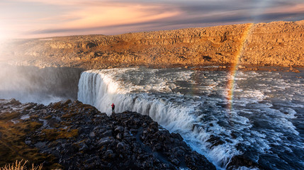 Iceland waterfall during sunset. Tipical Icelandic nature landscape. Dettifoss waterfall with rainbow under sunlit in magical landscape. Iconic location for landscape photographers in North Iceland