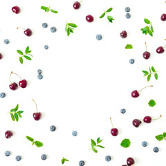 Deliciouse cherry and blue berries with mint isolated on white background. Top view. Flat lay frame