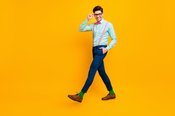 Fototapeta na wymiar Full size profile photo of cool stylish guy boyfriend walk down street date girlfriend wear specs shirt bow tie suspenders trousers shoes isolated bright yellow color background
