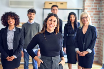 Obraz premium Group of business workers smiling happy and confident. Posing together with smile on face looking at the camera, young beautiful woman with crossed arms at the office