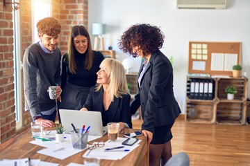 Group of business workers smiling happy and confident. Working together with smile on face  using laptop at the office
