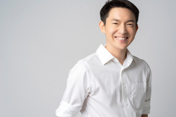 studio portrait of an attractive young asian businessman white shirt half body isolated on grey...